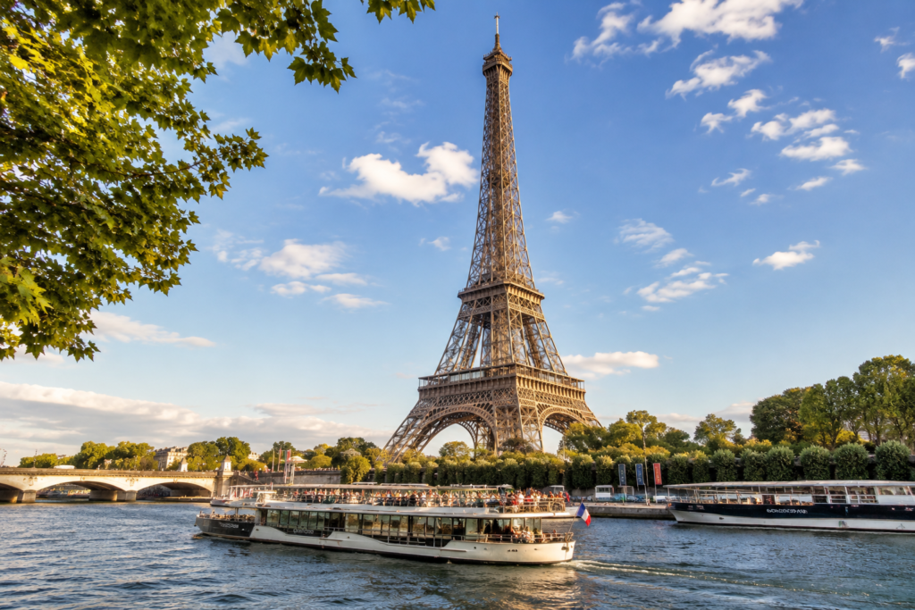 The Eiffel Tower standing above the Seine River on a bright sunny day in Paris, France