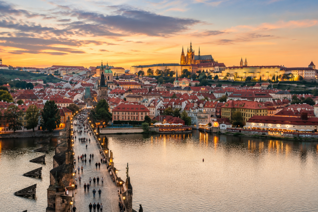Panoramic view of Prague featuring Charles Bridge and Prague Castle at sunset