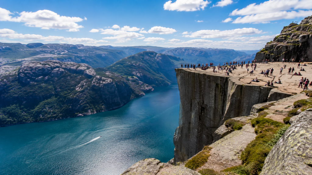 Tourists enjoying panoramic views from Preikestolen (Pulpit Rock) above Lysefjord in Norway