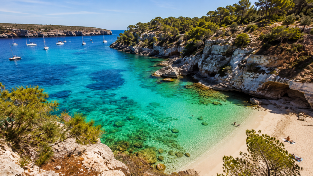 Turquoise Mediterranean cove surrounded by limestone cliffs in Mallorca, Spain